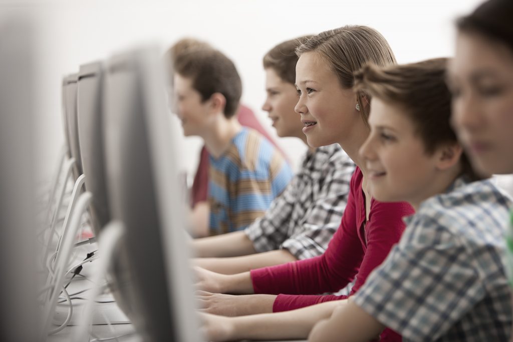 Jóvenes de entre 12 y 17 años de edad en un laboratorio de computación y tecnología, en una clase de tecnología digital. | FEDT