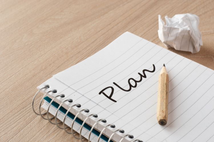 Cuaderno con la palabra “Plan” y lápiz simboliza un plan de formación en constante desarrollo, ajustado a nuevas ideas y necesidades educativas reales.